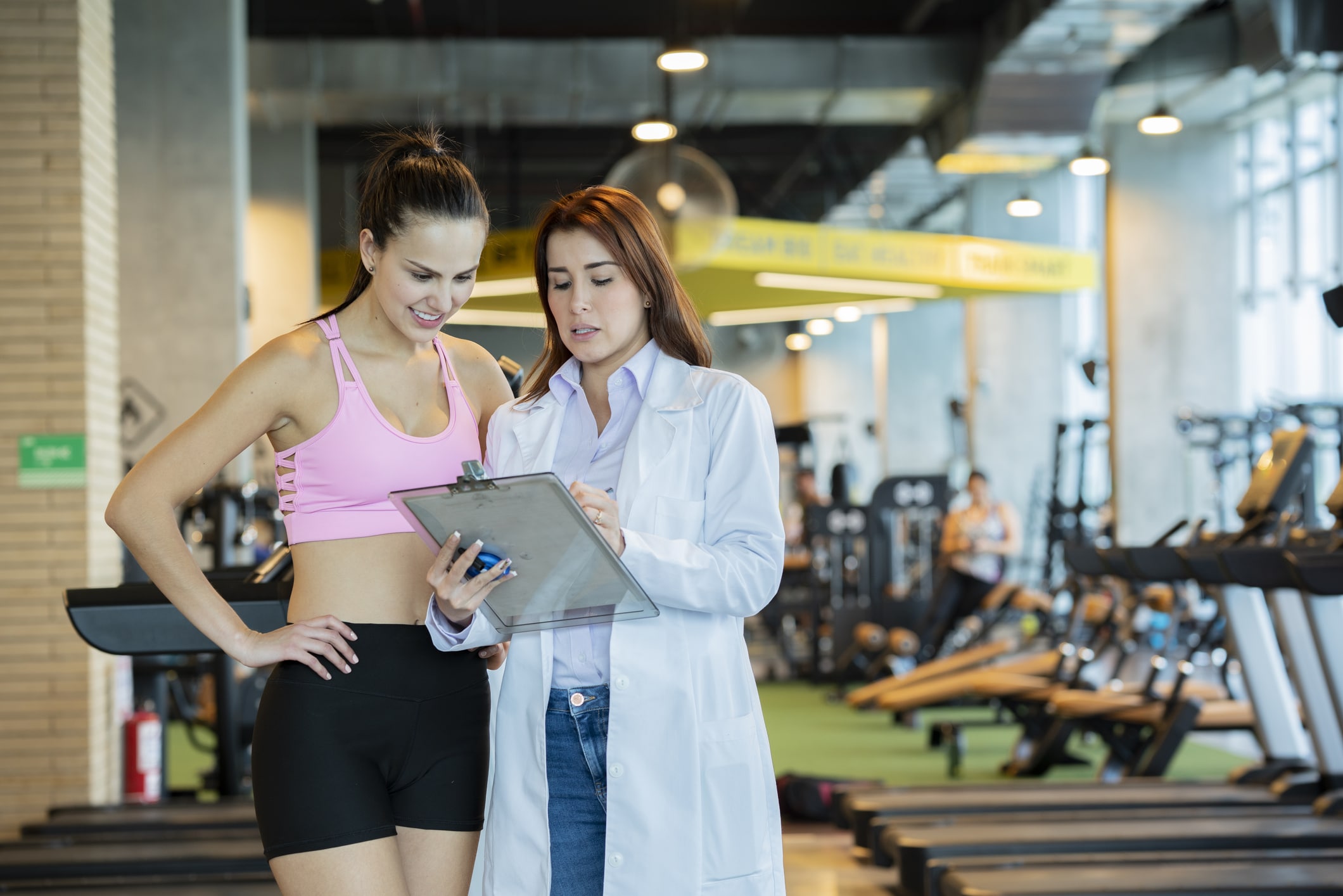 Sports Nutrition Dietitian 1 Dietitian Group Sports Medicine, Working In A Gym, Is In Charge Of Taking Care Of Athletes, Shows The Instructions Of A Plan To Follow An Athlete