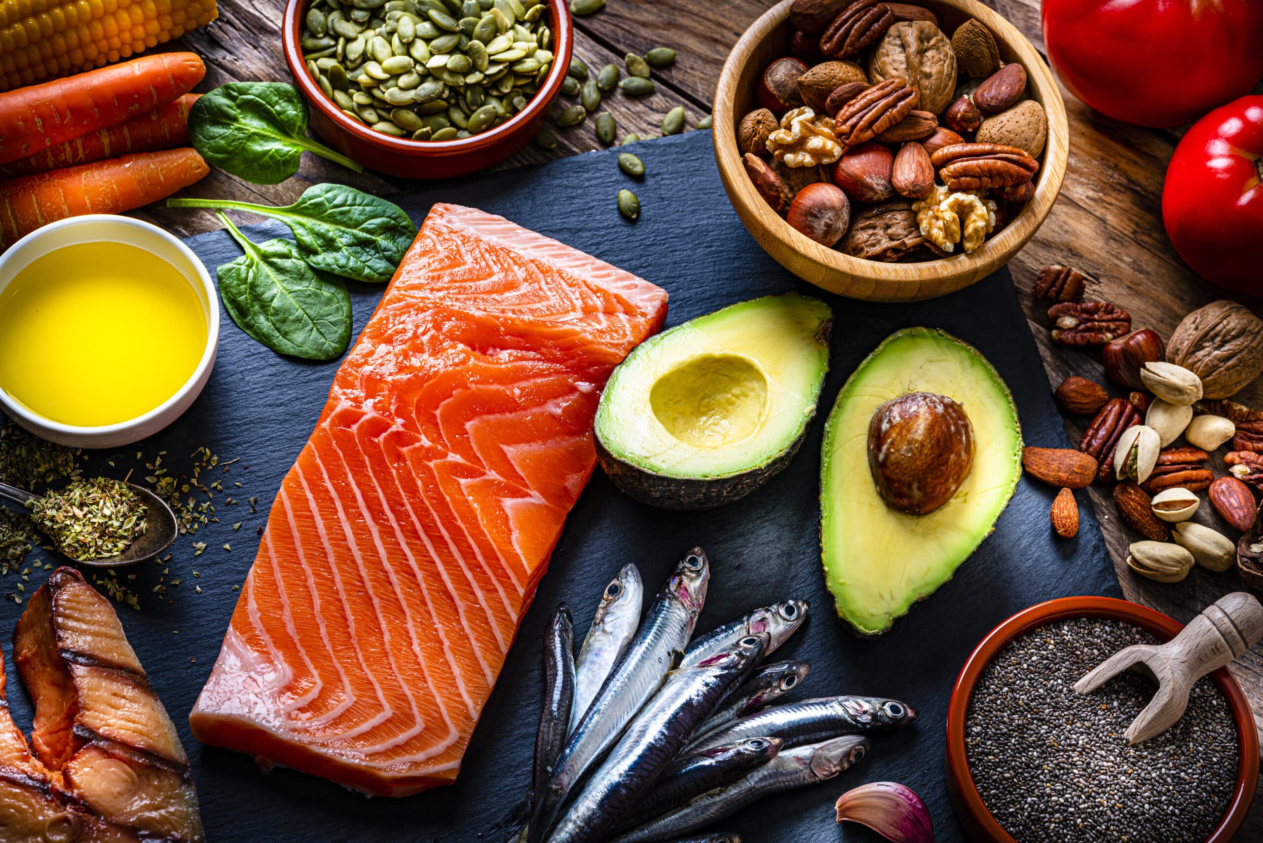 Healthy Eating: High Angle View Of A Group Of Food With High Levels Of Omega-3 Fat. The Composition Includes Salmon, Sardines, Avocado, Extra Virgin Olive Oil, And Various Nuts And Seeds Like Pumpkin Seeds, Chis Seeds, Pecan, Almonds, Pistachio, Walnuts And Hazelnuts. High Resolution 42Mp Studio Digital Capture Taken With Sony A7Rii And Sony Fe 90Mm F2.8 Macro G Oss Lens
