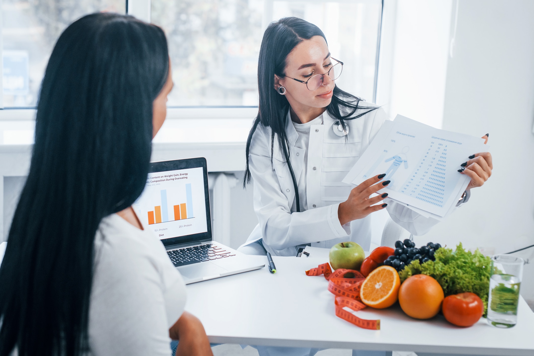 Female Nutritionist With Laptop Gives Consultation To Patient Indoors In The Office.