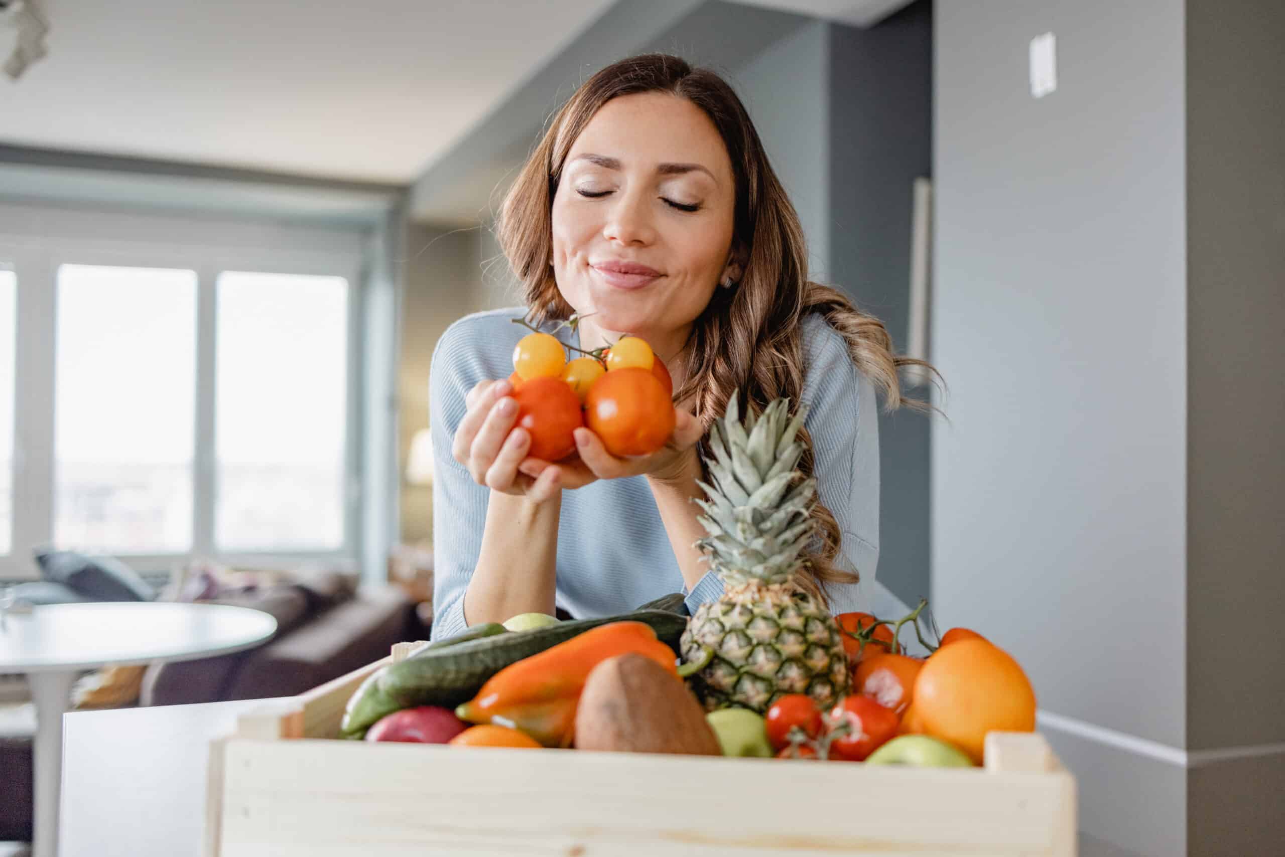 A Woman Holds Vegetables In Her Hand And Smiling