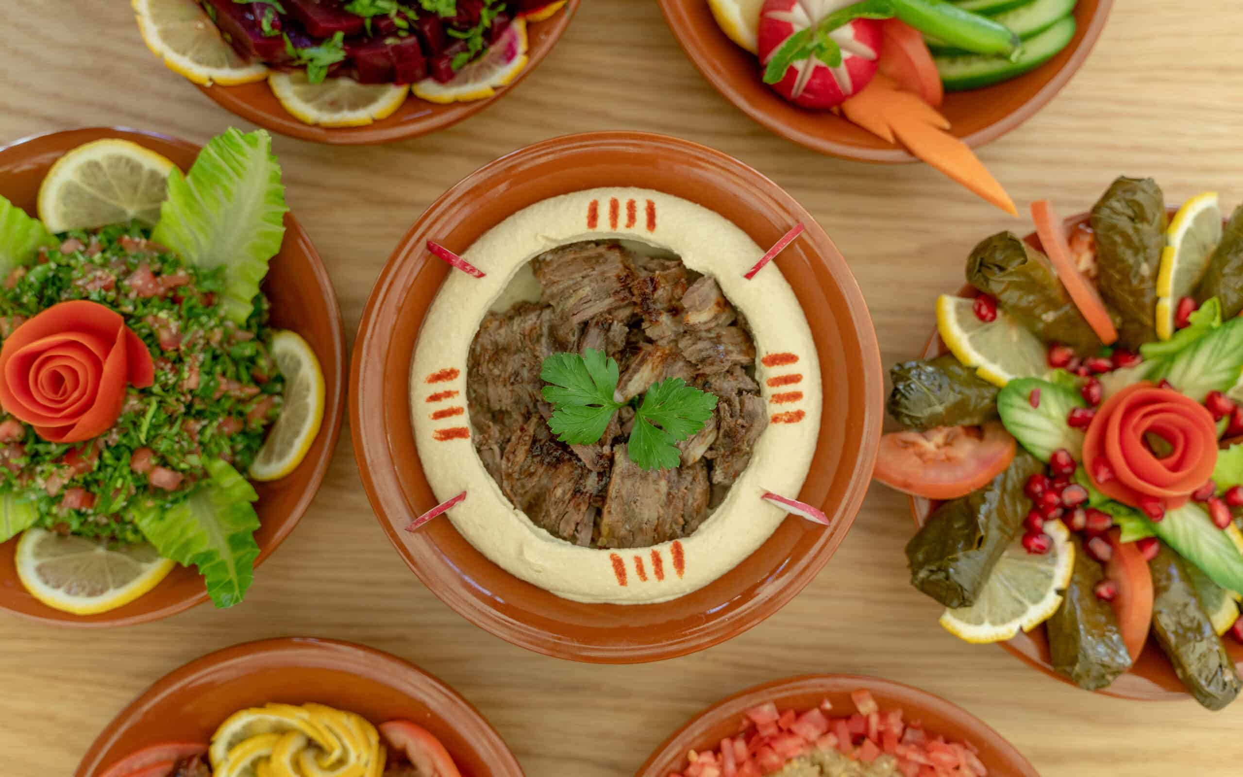 Multiple Lebanese Appetizers And Salads Togeather On The Table. Focused On Hummus