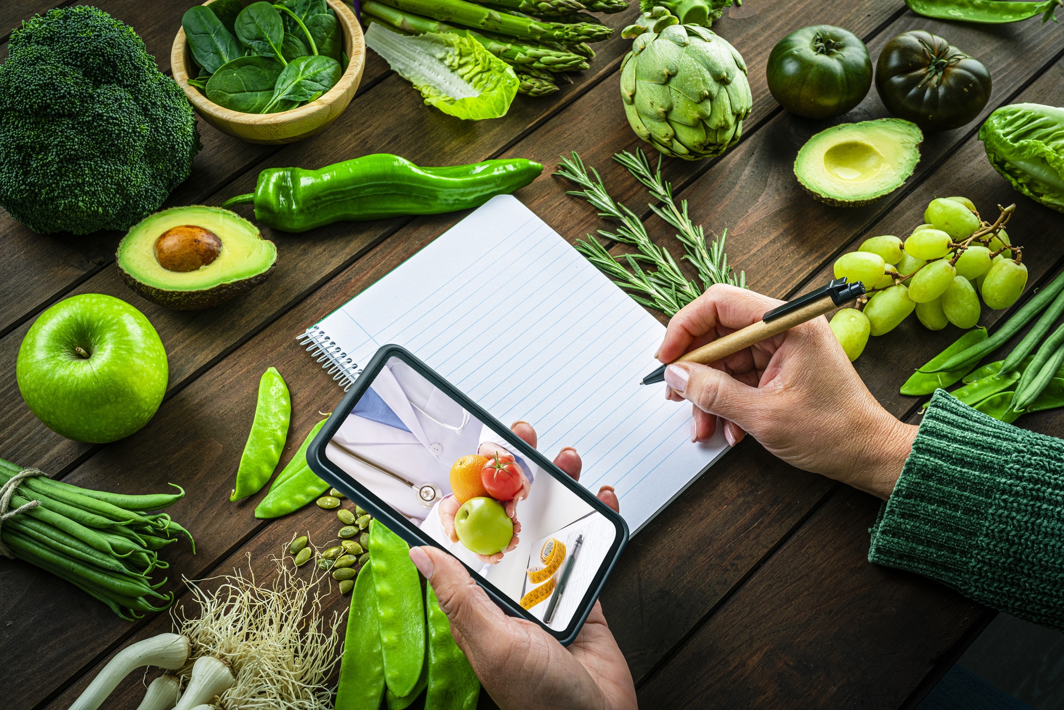 Woman Holding Smartphone Talking With Nutritionist About The Benefits Of Eating Fresh Fruits And Vegetables.