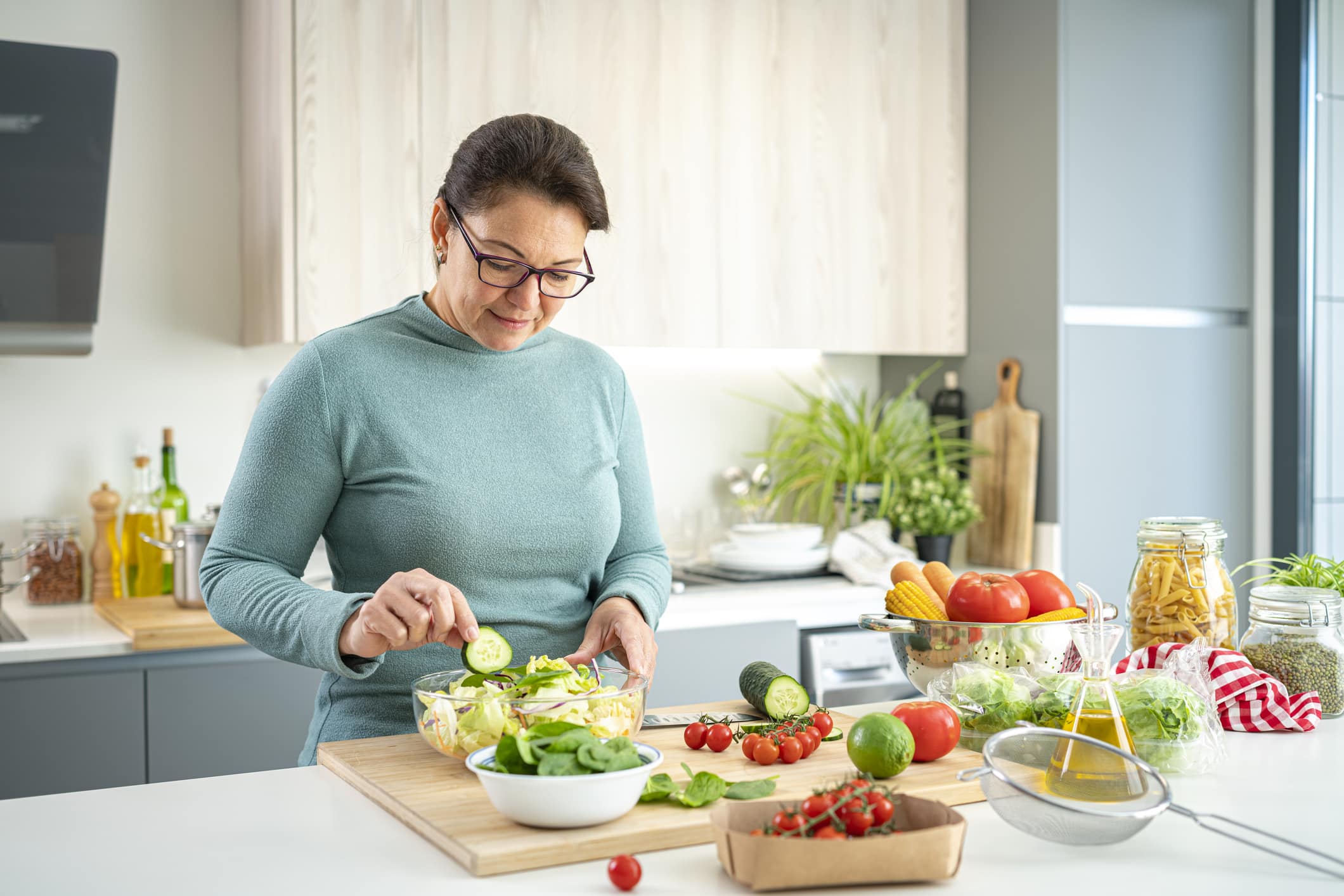 Healthy Eating: Mature Hispanic Woman Preparing Healthy Salad In Domestic Kitchen. High Resolution 42Mp Indoors Digital Capture Taken With Sony A7Rii And Zeiss Batis 40Mm F2.0 Cf Lens