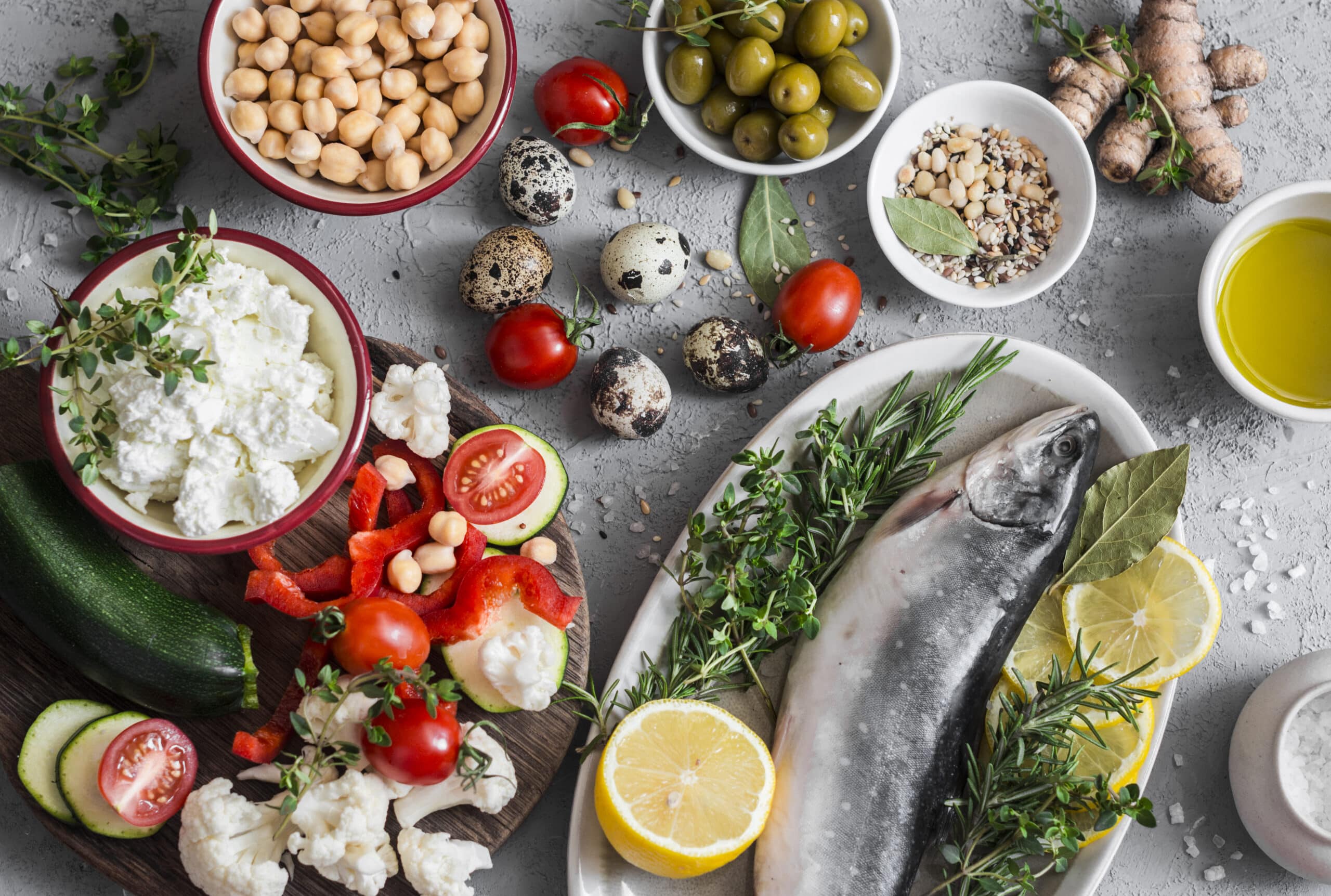 Mediterranean Style Food Background. Fish, Vegetables, Herbs, Chickpeas, Olives, Cheese On Grey Background, Top View. Healthy Food Concept. Flat Lay