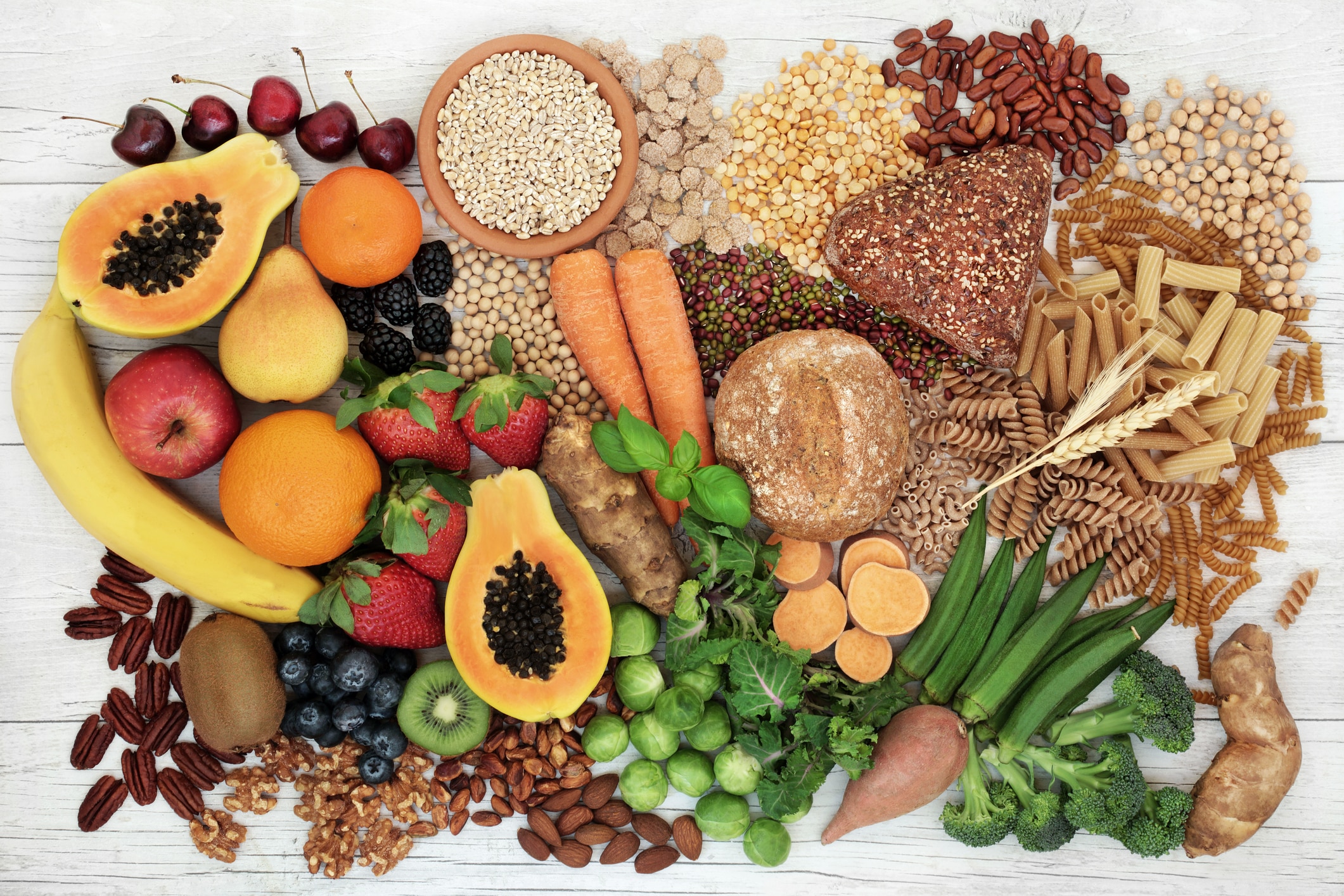 Food With High Fiber Content For A Healthy Diet With Fruit, Vegetables, Whole Wheat Bread, Pasta, Nuts, Legumes, Grains And Cereals. High In Antioxidants, Anthocyanins, Vitamins And Omega 3 Fatty Acid. Rustic Background Top View.
