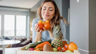 lady smelling different fruits and vegetables