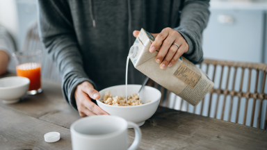 woman pouring milk in bowl