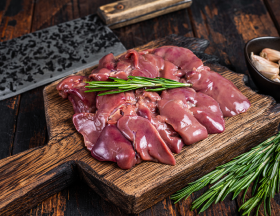 Raw liver on cutting board with rosemary
