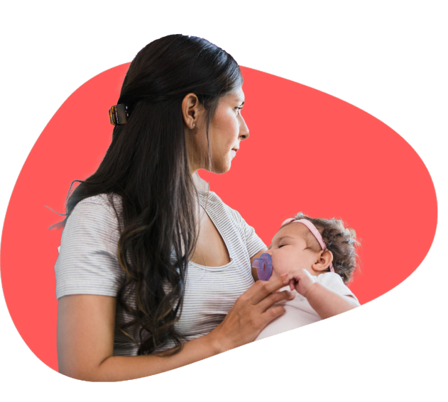 Lady holding a sleeping baby with a headband and pacifier