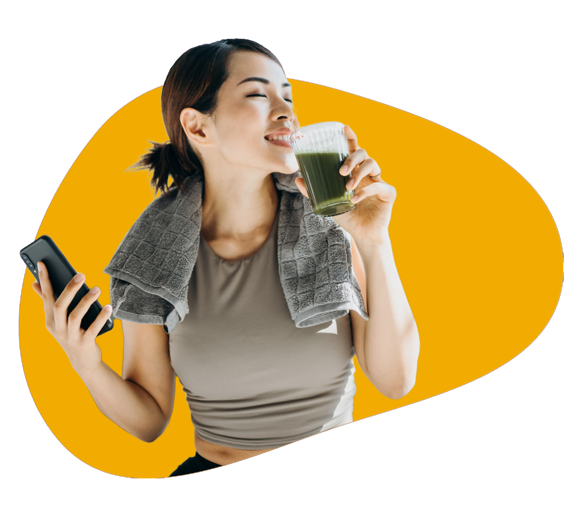 Lady drinking juice after exercise with phone in the other hand.