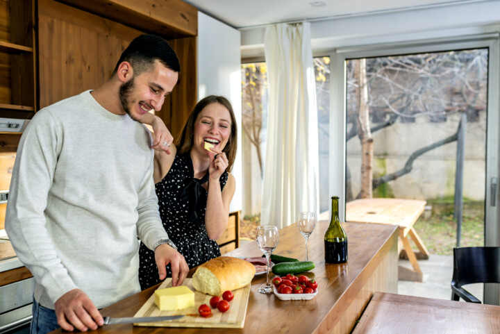 Attractive Young Couple Enjoying Anniversary With Delicious Appetizers and Bottle of Wine