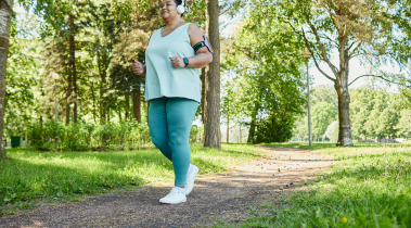 Person wearing headphones is seen jogging outside in a forest area.