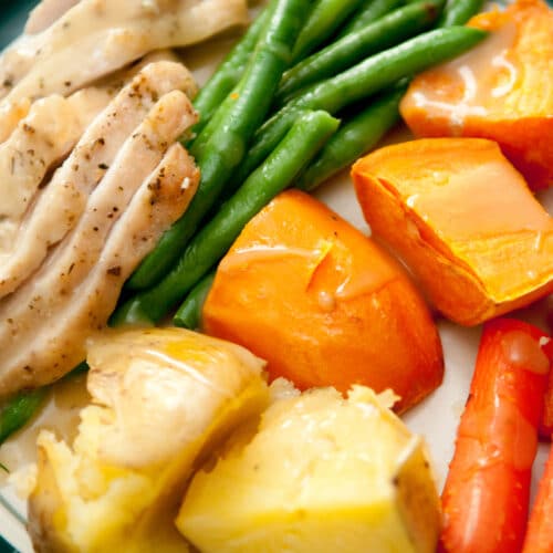 A Plate Of Spiced Chicken And Steamed Vegetables