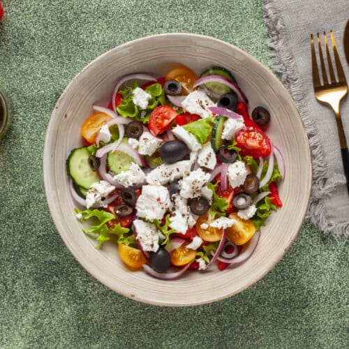 Greek Salad Of Fresh Cucumber, Tomato, Sweet Pepper, Arugula, Red Onion, Feta Cheese And Olives With Olive Oil. Healthy Food. Top View