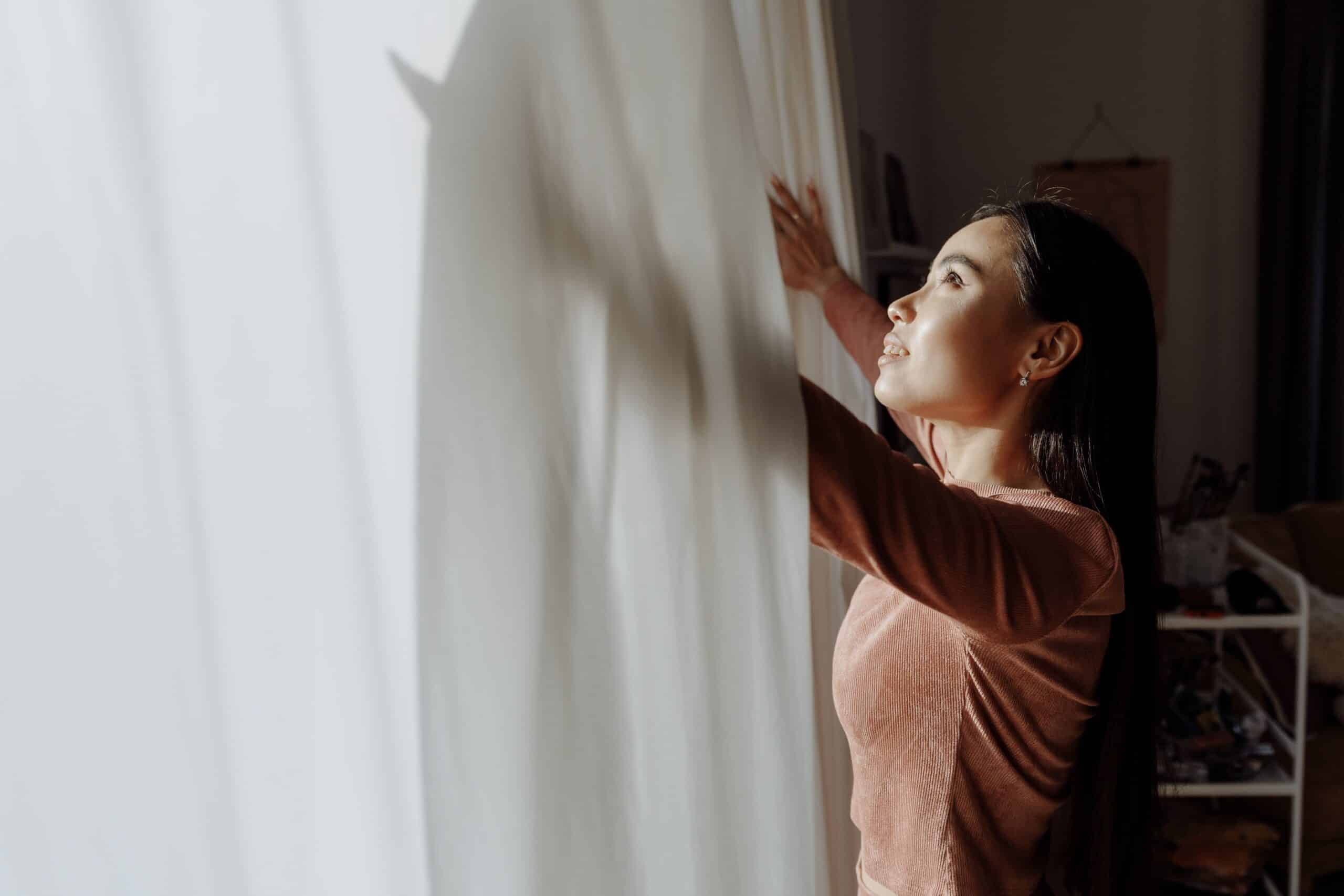 Woman Opening Curtains In Hopeful Morning Light, Representing Pcos Diet And Fertility Support